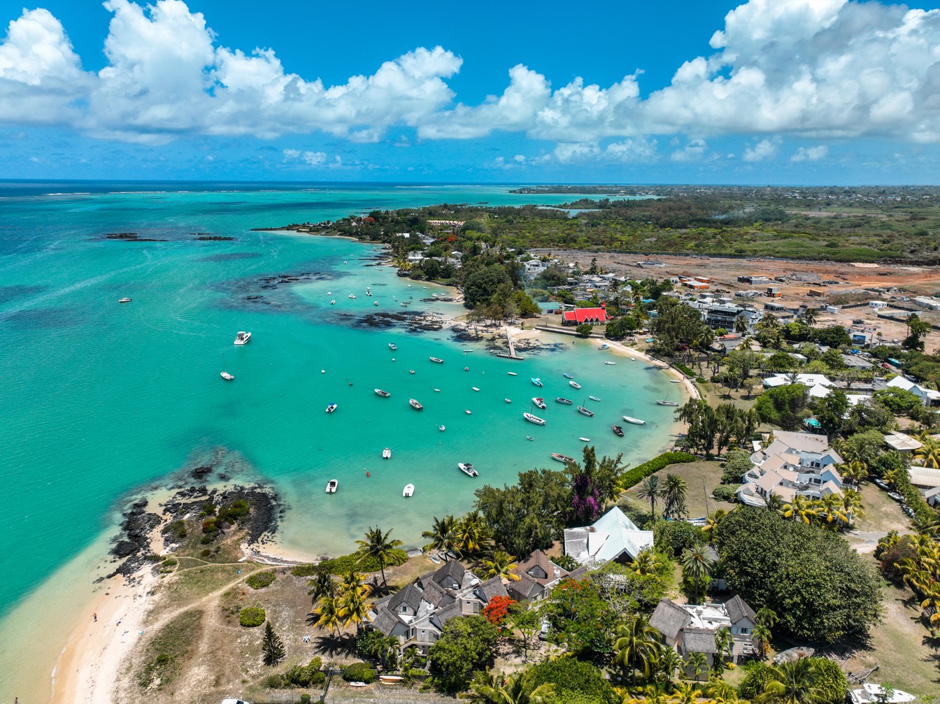 Village côtier vibrant avec lagon turquoise et bateaux dans une scène paisible