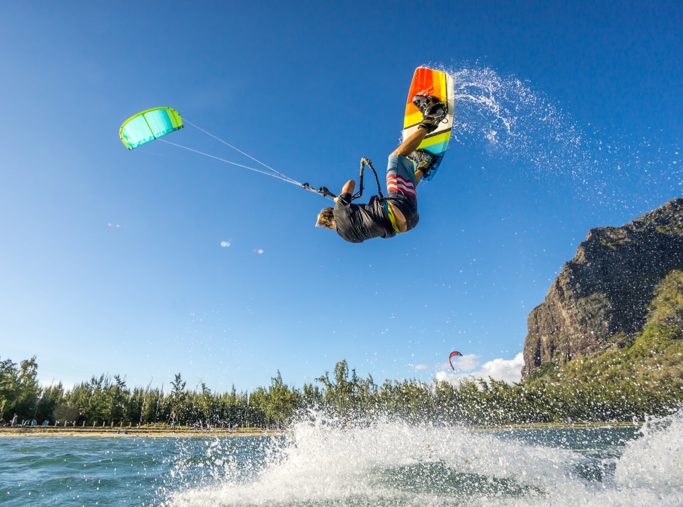 Kitesurf à Le Morne, avec un rider sautant au-dessus des vagues sous un ciel bleu