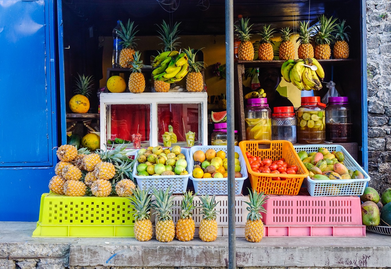 Étal de marché local avec ananas, bananes et divers fruits frais
