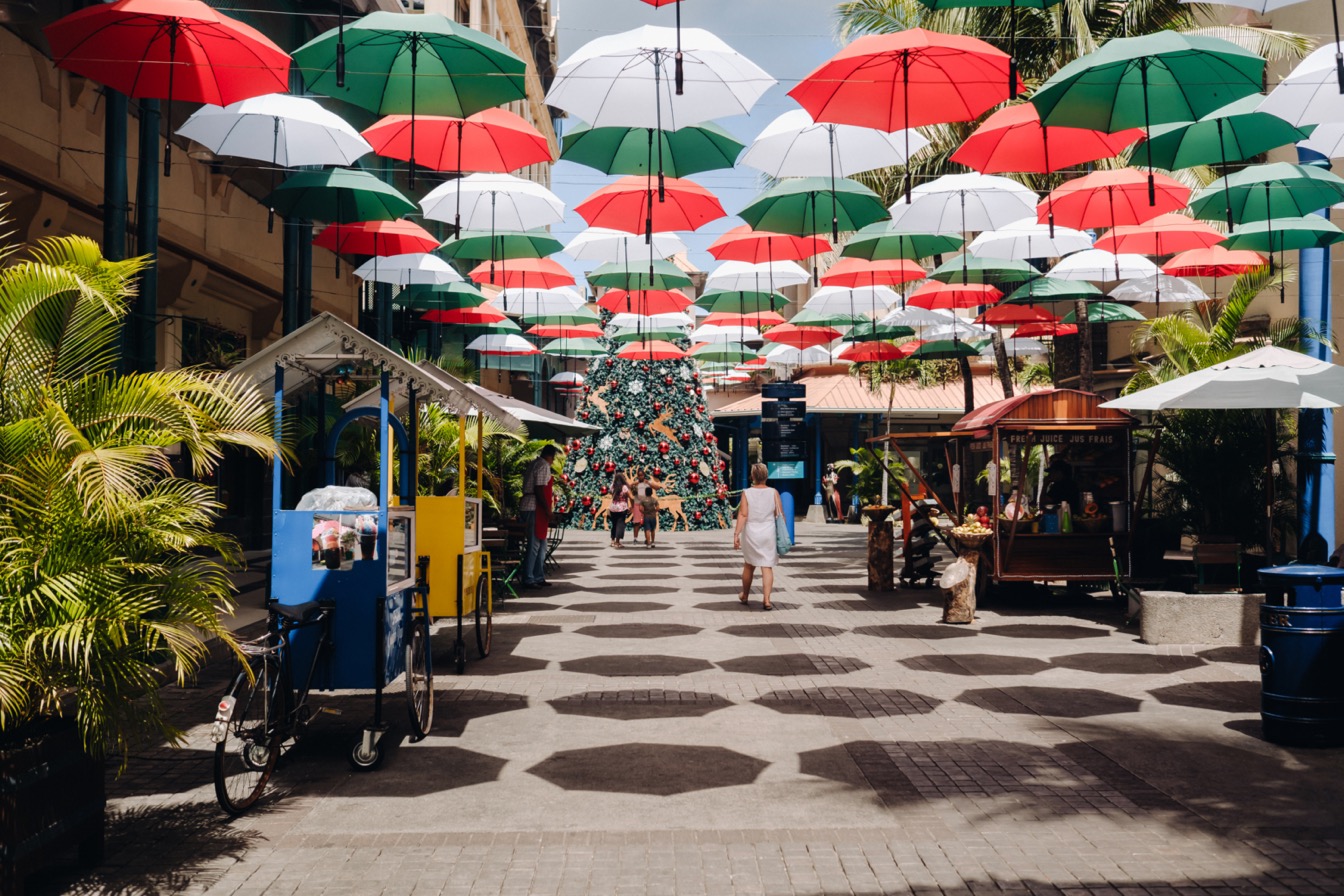 Port-Louis, allée décorée de parapluies colorés et de stands de marché